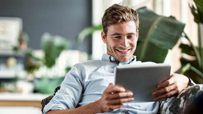 Smiling man looking at a tablet
