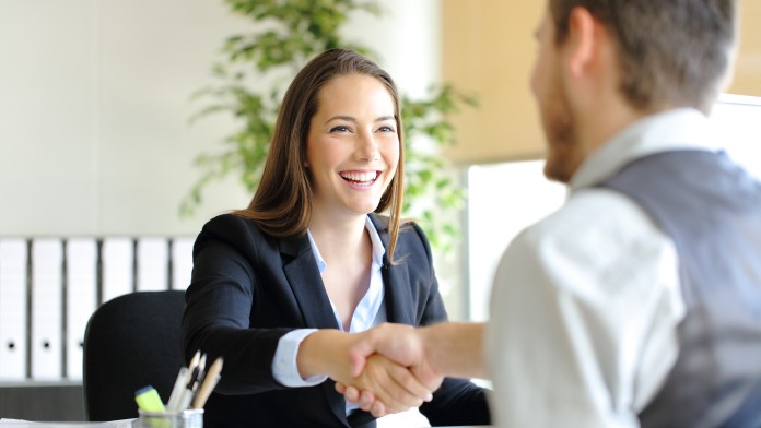 Young woman and man from behind shaking hands