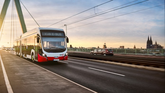 E-Bus auf einer Brücke mit Kölner Dom im Hintergrund