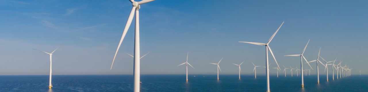 Windkraftanlagen im Meer vor blauem Himmel